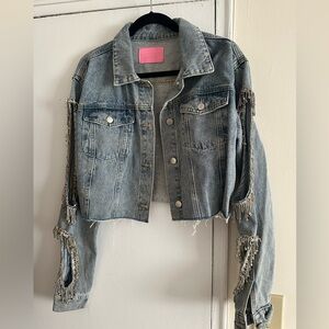 Cropped denim jacket with arm cutouts.